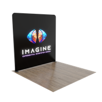 A trade show display with the word 'IMAGINE' and a colorful graphic, presented on a black background, stands in an exhibition space.